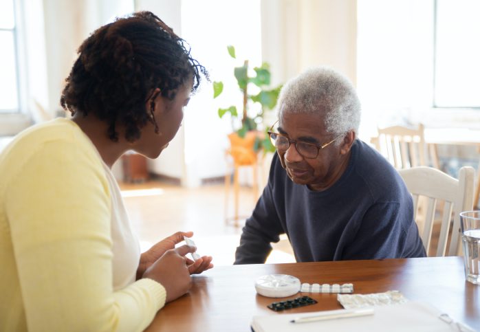 women helping elderly sort medicine