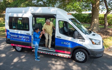 employee helping customer out of van