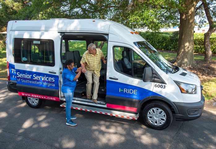 employee helping customer out of van