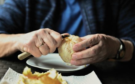 older adult peeling orange