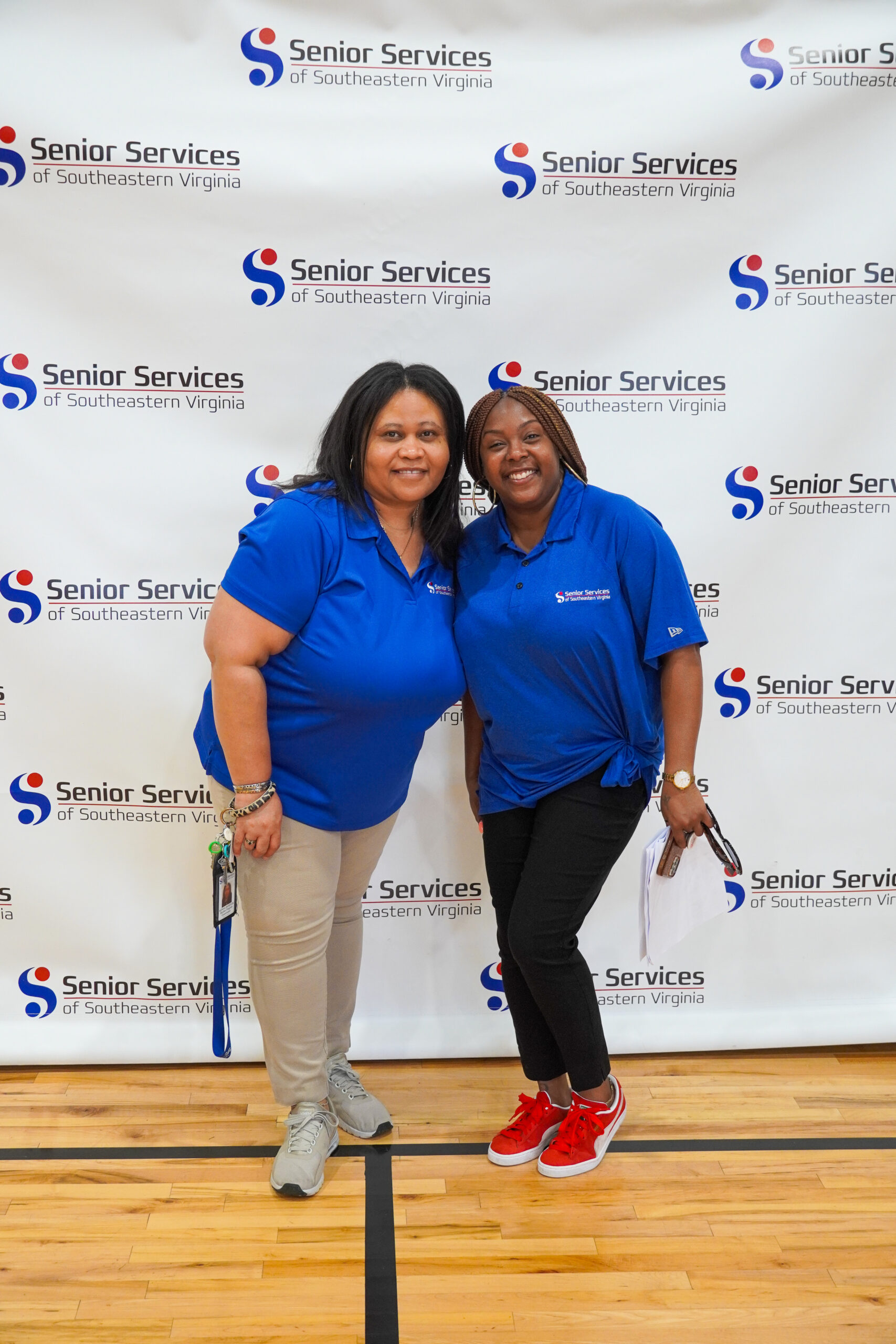 women posing for camera with senior services background
