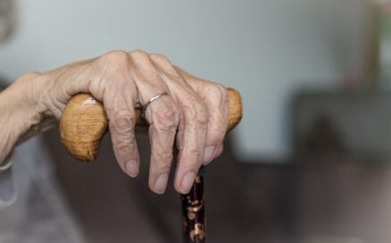 elderly white hand holding top of cane