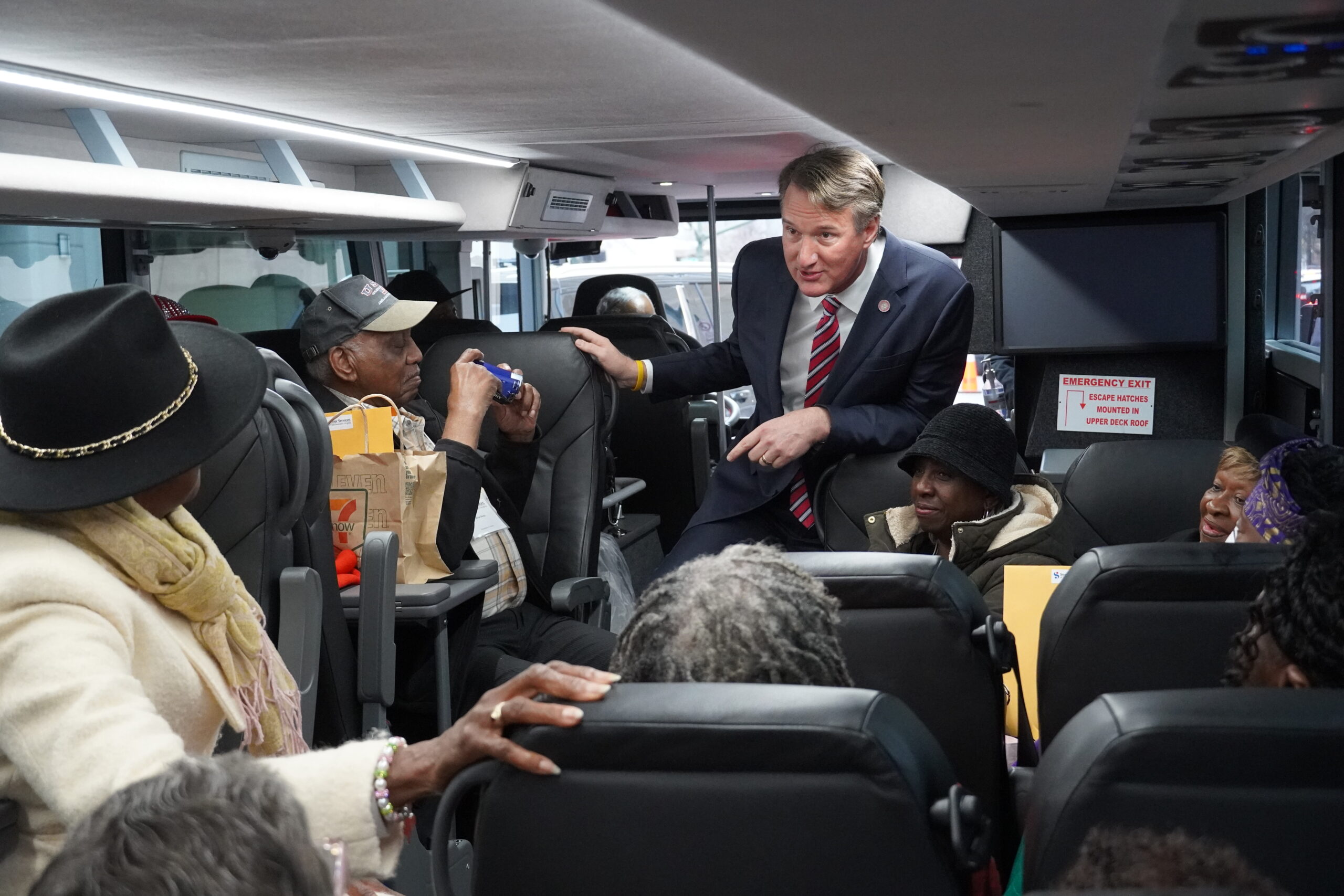 Governor Glen Youngkin on a bus talking to seniors